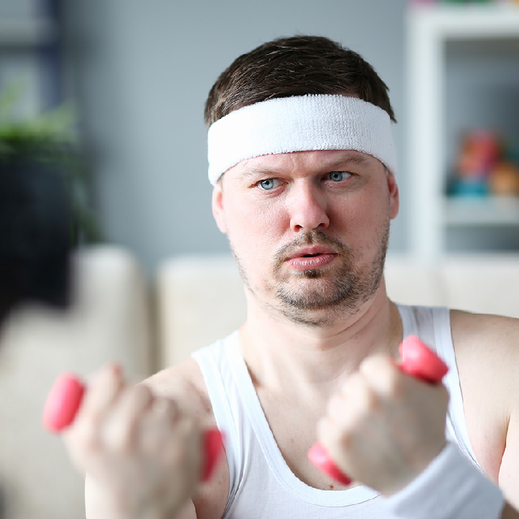 Harry Smith waering a headband and lifting comically small pink weights